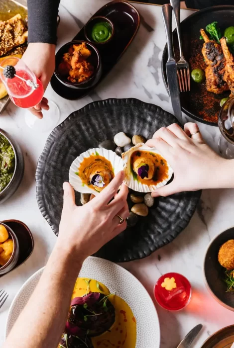 People sharing and enjoying a variety of dishes.